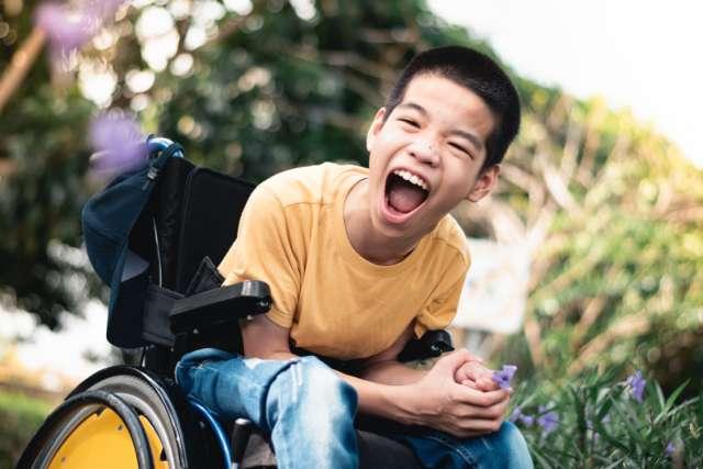 一个坐在轮椅上的孩子带着快乐的微笑.
